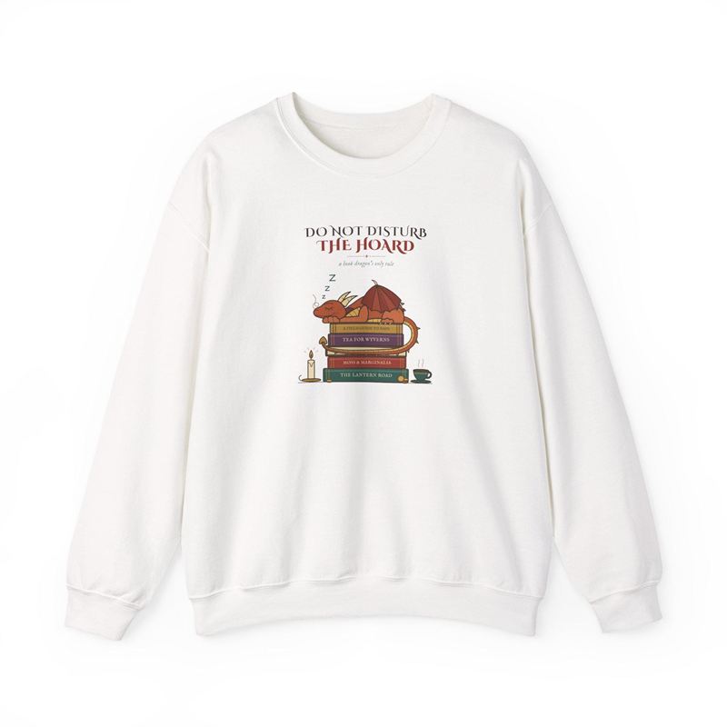 White crewneck sweatshirt with a chest print of a dragon asleep on a stack of books under Do Not Disturb the Hoard