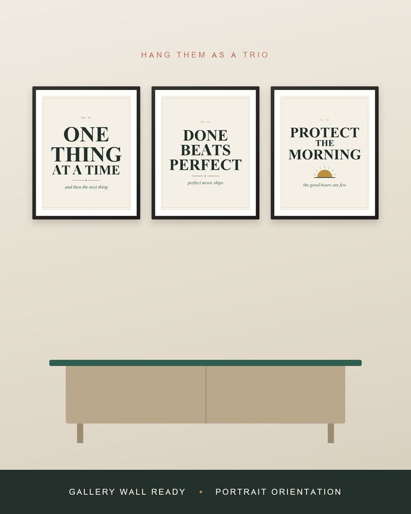 The home office prints framed in black as a row of three above a light wood sideboard