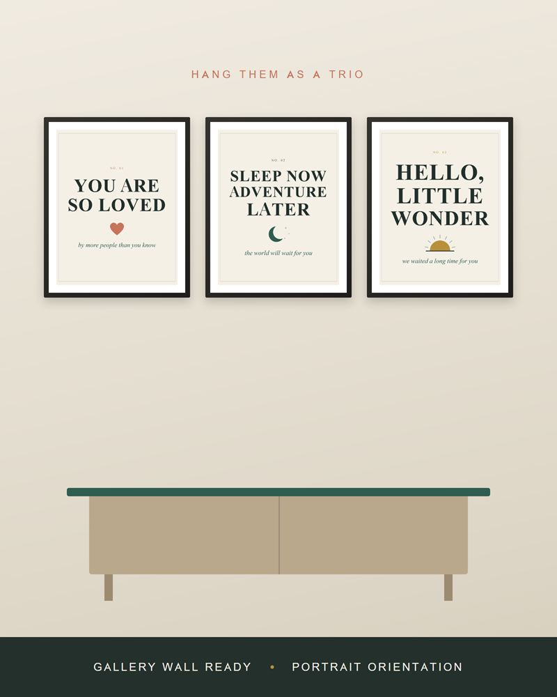 The nursery prints framed in black as a row of three above a light wood sideboard