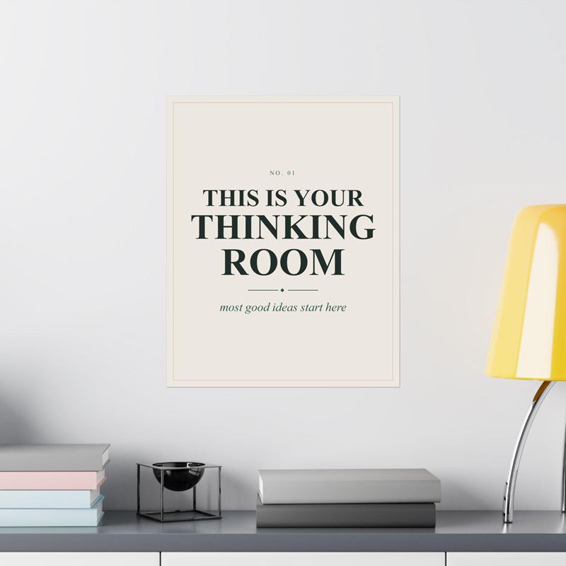 Cream poster reading This Is Your Thinking Room with "most good ideas start here", on a white wall by a lamp